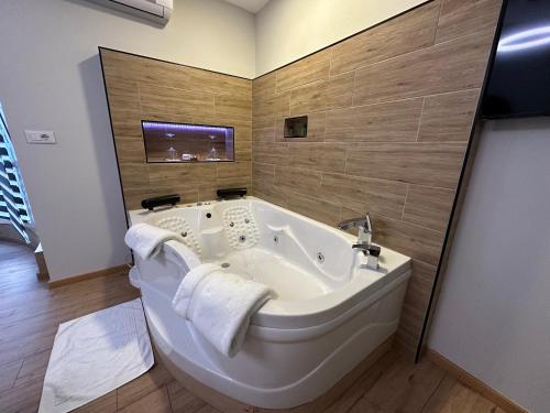 a bathroom with a large tub and a tv at Deluxe Apartment In City Center in Tirana