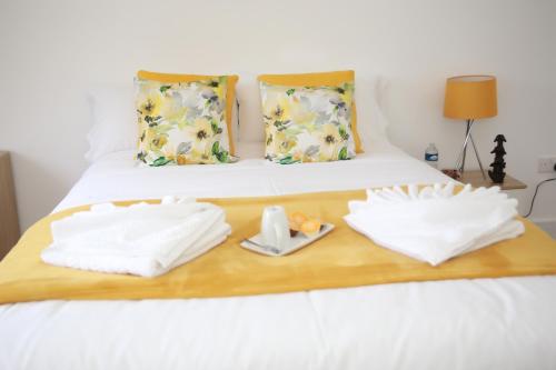 a bed with two towels on a wooden tray at Deluxe 4 bedroom House in The Hyde