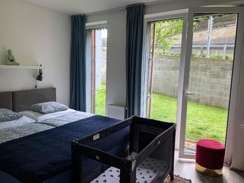 sypialnia z łóżkiem i dużym oknem w obiekcie Jezerní apartmán s terasou a saunou v Lakepark Residence w mieście Doksy