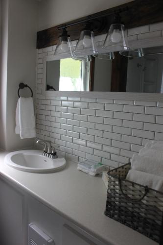 Port Sydney的住宿－特里魯姆溫泉度假酒店，浴室配有盥洗盆、镜子和毛巾