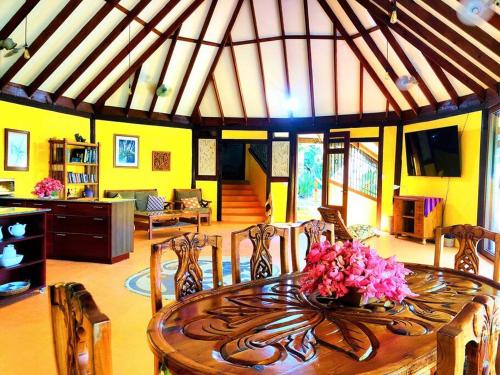 a dining room with a table with flowers on it at Villa del Idaan in Bocas del Toro