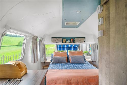 una cama en la parte trasera de una caravana en Airstream, Devon Hideaways, en Kenton