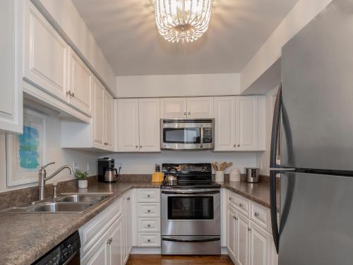 a kitchen with white cabinets and a stainless steel refrigerator at 1129 Summerwind Cottage in Seabrook Island