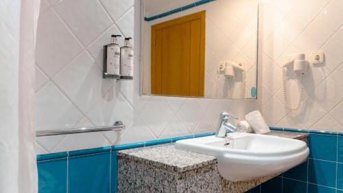 łazienka z umywalką i lustrem w obiekcie Rosamar Ibiza Hotel w mieście San Antonio Bay
