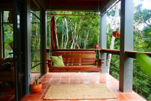 a screened in porch with a bench in the woods at RiverHill Hideaway in Monkey Fall