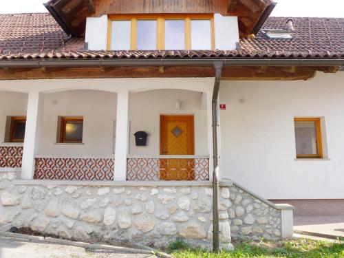 ein Haus mit einer Steinmauer und einer braunen Tür in der Unterkunft Apartment Jalps 1 in beautiful Bohinjska Bistrica in Bohinj