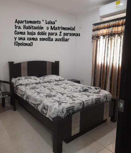 a bed in a room with a poster on the wall at Apartamentos LUISA in Coveñas