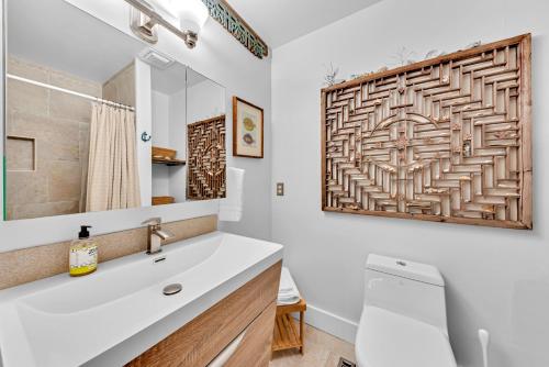 um banheiro com uma pia branca e um espelho em 804 Treeloft Cottage em Seabrook Island