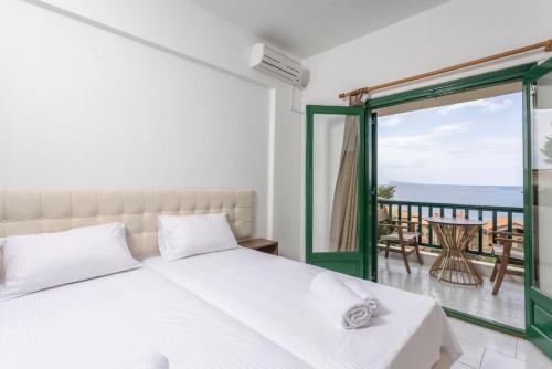 ein Schlafzimmer mit einem Bett und einem Balkon in der Unterkunft D&G Apartments in Agia Paraskevi