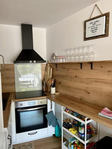Il comprend une cuisine équipée d'une cuisinière et une télévision. dans l'établissement Les Caravelles - Appartement Une chambre avec parking proche plage, au Grau-du-Roi