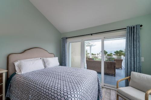 um quarto com uma cama e uma porta de vidro deslizante em 2940 Atrium Villa em Seabrook Island