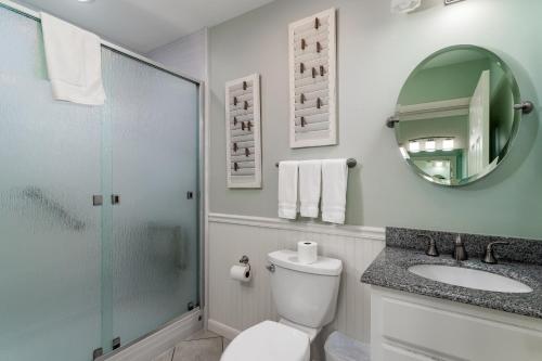 uma casa de banho com um WC, um lavatório e um espelho. em 2940 Atrium Villa em Seabrook Island
