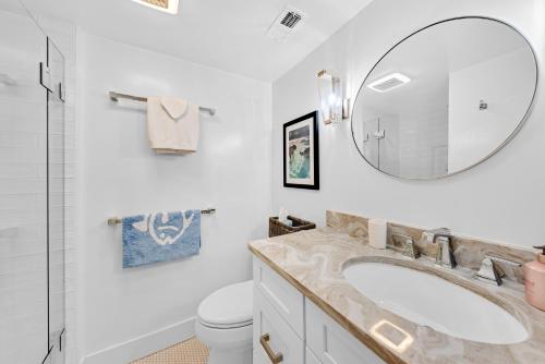 Un baño blanco con lavabo y espejo. en 1345 Pelican Watch Villa, en Seabrook Island