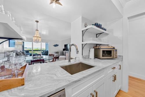a kitchen with a sink and a living room at 1345 Pelican Watch Villa in Seabrook Island