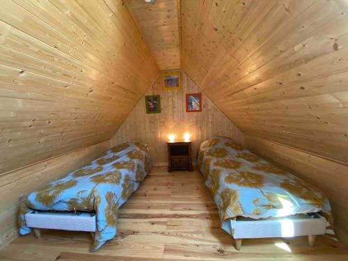 - une chambre avec 2 lits dans une cabane en bois dans l'établissement Nouveau - La grange de Saint-Sulpice, à Bellengreville
