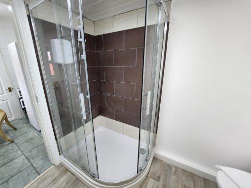 a shower with a glass door in a bathroom at Sheldon Shared House in Birmingham