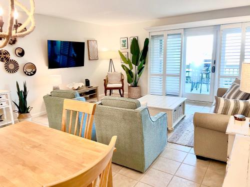 a living room with couches and a table at 1391 Pelican Watch Villa in Seabrook Island