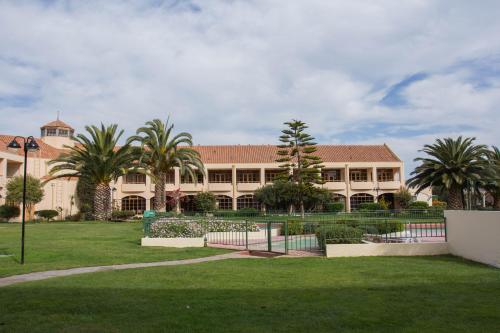 a large building with palm trees in front of it at Hotel y Departamentos La Serena - Caja Los Andes in La Serena