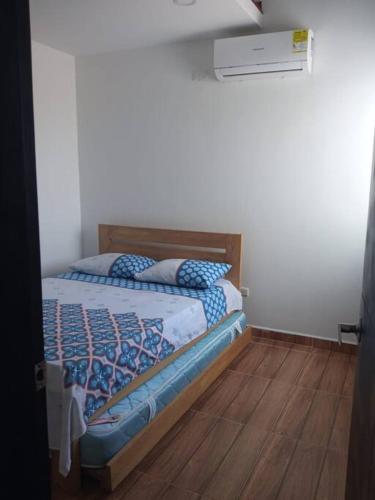 a bedroom with a bed with a wooden floor at Apto en Coveñas cerca al mar in Coveñas
