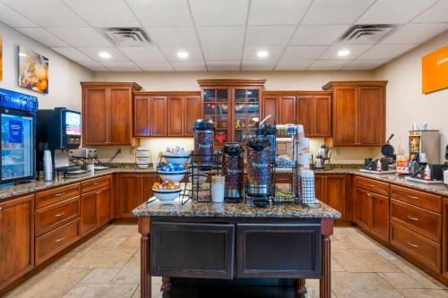 a large kitchen with wooden cabinets and a counter top at Comfort Inn & Suites Watertown - 1000 Islands in Watertown