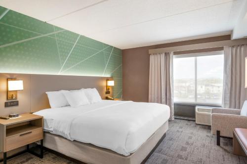 a hotel room with a large bed and a window at Comfort Inn & Suites Watertown - 1000 Islands in Watertown