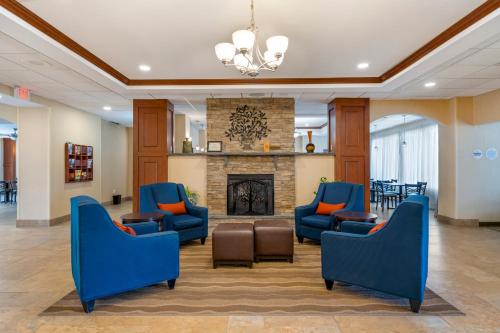 a lobby with blue chairs and a fireplace at Comfort Inn & Suites Watertown - 1000 Islands in Watertown