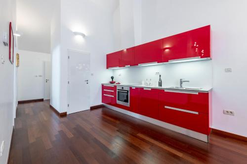 a red kitchen with white walls and wooden floors at Magic Sunset Suite in Dubrovnik