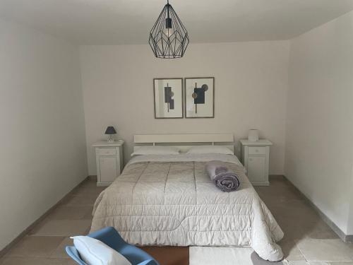 1 dormitorio blanco con 1 cama y 2 mesitas de noche en Cactus e ulivi villa a Speziale, en Montalbano
