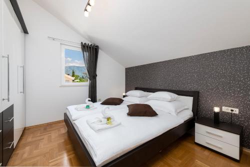 a bedroom with a large bed with white sheets and brown pillows at Magic Sunset Suite in Dubrovnik