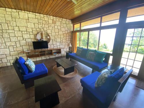 a living room with blue couches and a stone wall at Frenchman's Cove Resort in Port Antonio
