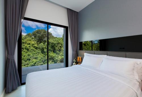 a bedroom with a large white bed and a large window at Utopia Villa Naiharn Beach in Nai Harn Beach