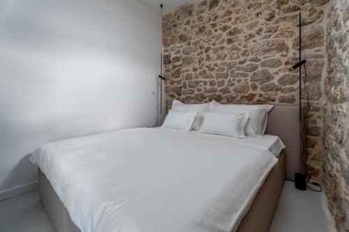 a bed in a room with a brick wall at Murvica resport in Murvica