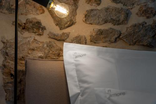 a stone wall with a lamp and a white envelope at Murvica resport in Murvica