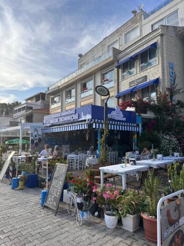 a restaurant with tables and flowers in front of a building at Larimar Hotel Cesme in Çeşme