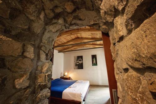 ein Schlafzimmer in einer Steinmauer mit einem Bett in einem Zimmer in der Unterkunft Holiday home Raos - a special stonehouse, Brela in Brela