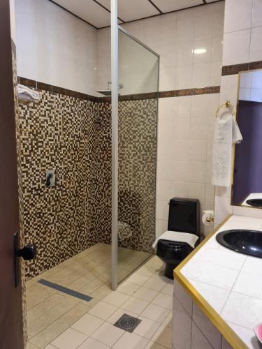 een badkamer met een douche, een toilet en een wastafel bij Glorieta Hotel in Sucre
