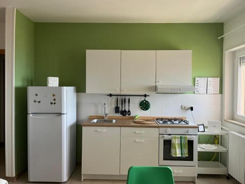 a kitchen with white appliances and a green wall at Il Mare di Giò in Monopoli