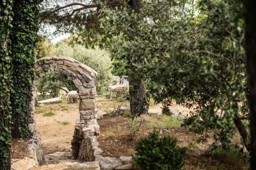 a stone archway in a garden with trees at Holiday home Raos - a special stonehouse, Brela in Brela
