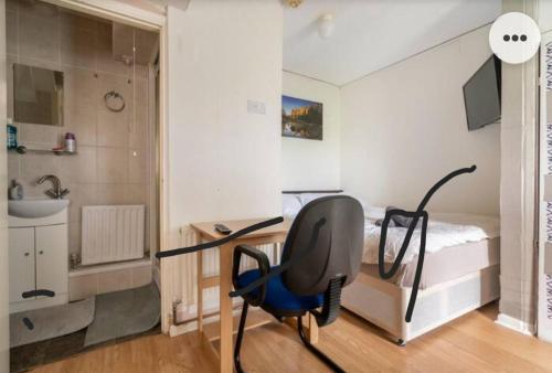 1 dormitorio con escritorio, 1 cama y 1 silla en Medway luxury Retreat free parking free wi-fi, en Chatham