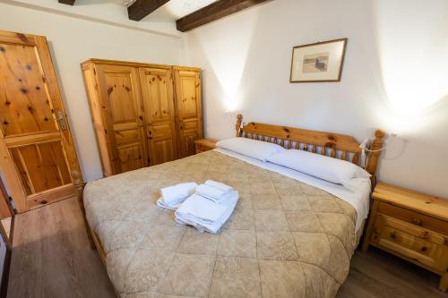 a bedroom with a large bed with two towels on it at Grazioso trilocale nel cuore di Folgaria in Folgaria