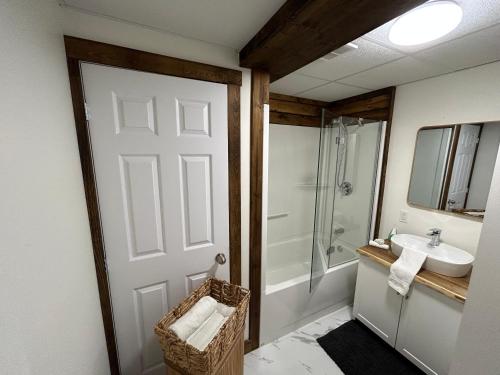 a bathroom with a shower and a sink and a door at Vébron 2 in LʼAnse-Saint-Jean