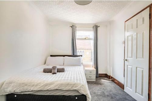un dormitorio con una cama con un animal de peluche en Maidstone castle 3bedroom free sports free parking, en Maidstone