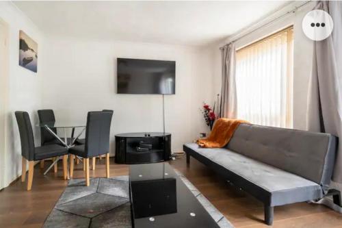 ein Wohnzimmer mit einem Sofa und einem Tisch in der Unterkunft Home in Medway 3bedroom free sports free parking in Chatham