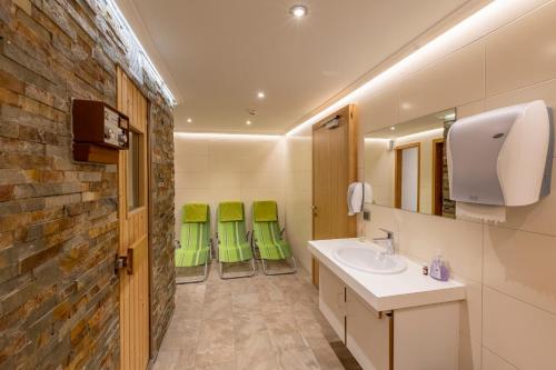 a bathroom with a sink and two greenchairs at Landhaus MONTANA in Rauris