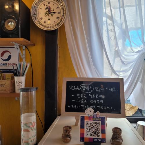 a desk with a clock and a table with a box at Soulmate Pension in Namhae