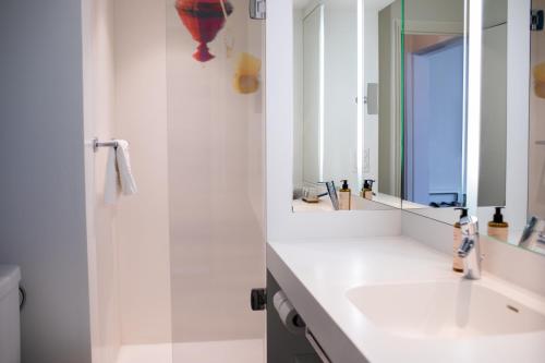 a bathroom with a sink and a mirror at Mercure Lorient Centre in Lorient