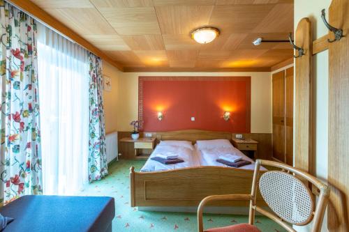 sypialnia z łóżkiem z czerwoną ścianą w obiekcie Landhaus MONTANA w mieście Rauris
