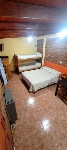 a room with two beds and a tv in it at Cabañas Clarita in Dina Huapi
