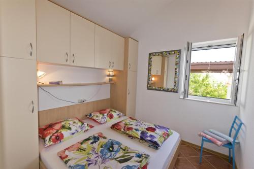 a small bedroom with a bed and a window at Apartment By the sea in Donje Selo na Šolti