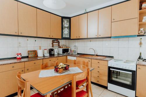 a kitchen with wooden cabinets and a table with chairs at Happy Home in Kavála
